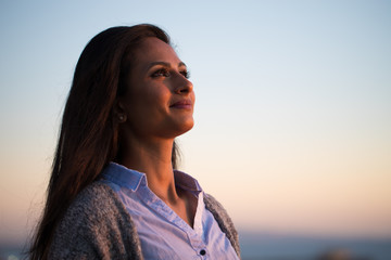 Young Indian woman looking up sunset sky 