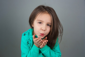 Cute lovely young girl sending a kiss over