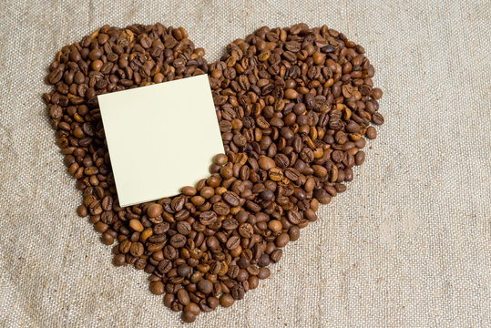 Spilled grains of fragrant coffee close-up. Photo frame, background. Heart of coffee beans. A declaration of love.