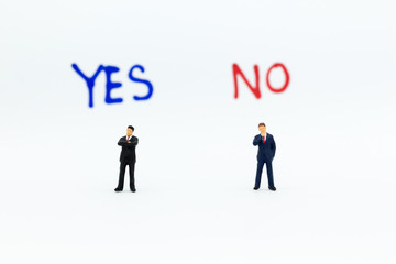 Miniature people: Businessman stand with 'YES or NO' word, pathway choice. Image use for business decision concept, new the way.