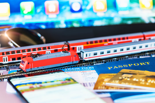 Toy train, tickets, passport and bank card on laptop or notebook