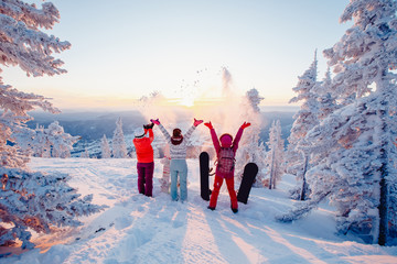 Happy team of snowboarders having fun tossing snow and fun.