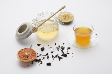 tea with honey in a glass on a white background