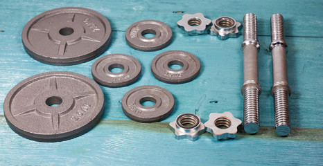 Top view of accessories for fitness in grey tone. Dumbbells, weight plates.