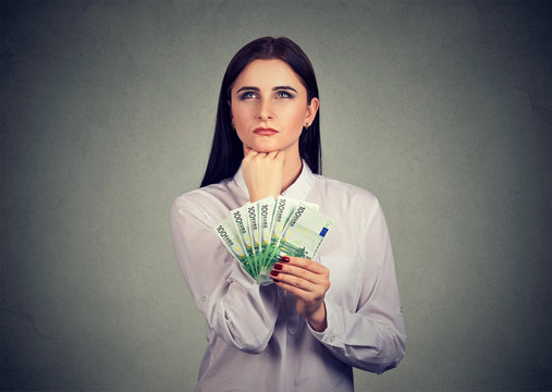 Woman with money deciding on spending