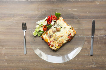 Lasagna with vegetables in a glass dish.