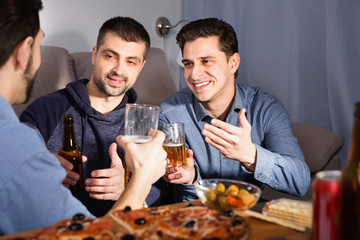 Friendly meeting in men company over beer with pizza