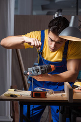 Worker working in repair workshop in woodworking concept