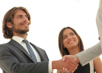 Businesspeople  shaking hands against room with large window loo