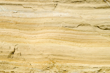 Obraz na płótnie Canvas A yellow sandstone with cracks closeup