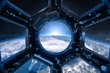 View from a porthole of space station on the Earth background. Elements of this image furnished by NASA. - obrazy, fototapety, plakaty