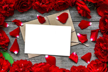blank greeting card in frame made of red roses flowers and petals