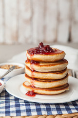 Pancakes stack on a plate with raspberry jam. Shrove Tuesday, pancake day, Maslenitsa. Traditional Russian holiday