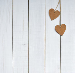 Valentines. valentines day concept. Two wooden hearts are linked  together coarse twine on white wooden background. Space for text
