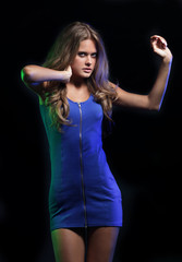 portrait of a dancing woman in a short dress, black background