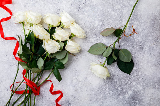 White Rose Bouquet Red Ribbon on a stone background Holiday Background Valentine's Day Top View Copy space for Text Flat Lay