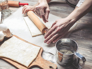 Fototapeta na wymiar Mother and the daughter cook dough for home-made pastries. Happy family concept. Female and children's hands using rolling pins
