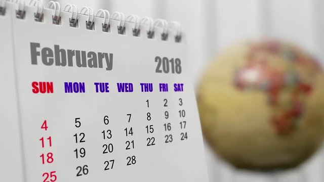 Motion of February 2018 calendar with blur earth globe turning background