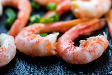 Cooked shrimps, prawns  with seasonings close up  on dark stone background
