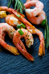 Cooked shrimps, prawns  with seasonings on dark stone background