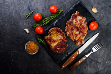 Fresh grilled meat  with spices on dark  background, top view.