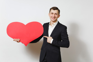 Young man in suit pointing index finger on big red heart isolated on white background. Copy space, advertisement. Place for text. St. Valentine's Day, International Women Day birthday holiday concept.