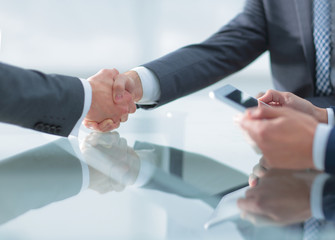 Two confident businessmen shaking hands during a meeting in the