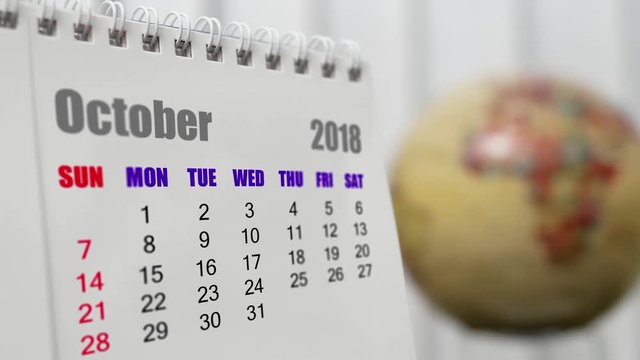 Motion of October 2018 calendar with blur earth globe turning background