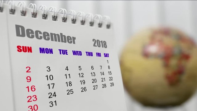 Motion of December 2018 calendar with blur earth globe turning background