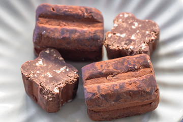 Italienische Trüffelpralinen - Tartufo dolce nero - auf hellgrauen Hintergrund