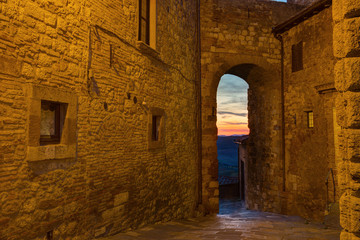 Montepulciano, Italy - view of the sunset through an old arch in a stone wall