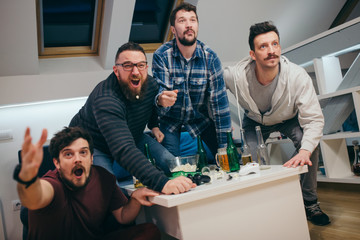 Group of friends watching sport on TV at home