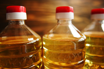 plastic bottles with sunflower oil on a wooden background close-up