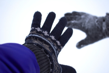 Hand in warm gloves in snow, close-up