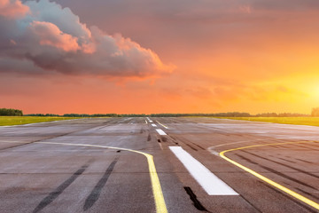 Start-en landingsbaan op de luchthaven de horizon bij zonsondergang in het midden van de zon.