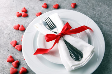Festive table setting for Valentine's Day with fork, knife and rose