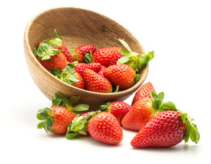 Garden strawberries out a wooden bowl isolated on white background.