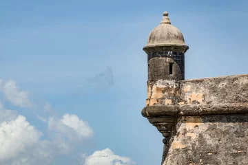 Cercles muraux Travaux détablissement La tour extérieure et le mur avec guérite du fort de San Felipe del Morro dans le vieux San Juan à Porto Rico, États-Unis contre le ciel bleu avec des nuages et un espace de copie