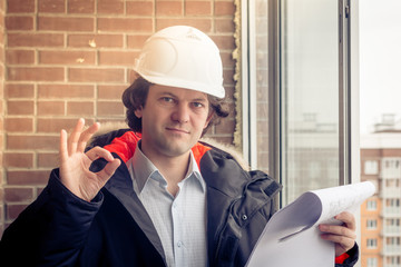 A construction worker gives you the okay sign, signaling that everything is a-okay. Soft focus, toned.