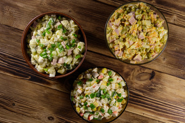 Set of festive mayonnaise salads on wooden table. Top view