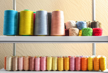 Set of color sewing threads and crocheting clews on shelves