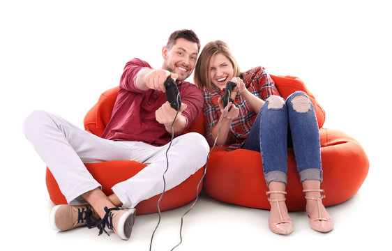 Emotional couple playing video game on white background