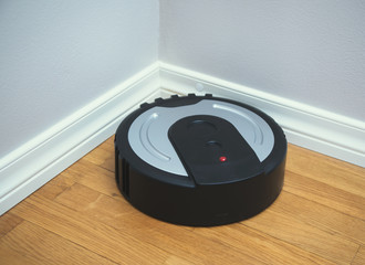 Black robotic vacuum cleaner on the floor.