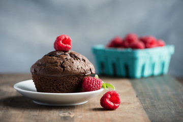 Chocolate muffins or cupcakes with raspberries, healthy breakfast, homemade snack, selective focus, toned image.