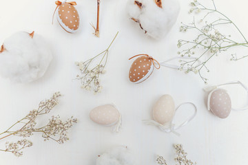 Easter decoration with eggs, cotton and White Flowers on a rustic white wooden background. Easter concept. Flat lay. Spring greeting card