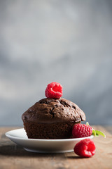 Chocolate muffins or cupcakes with raspberries, healthy breakfast, homemade snack, selective focus, toned image.