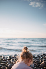 little girl playing on the beach in golden hour
