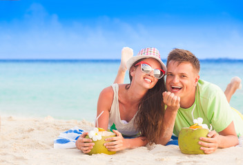 back view of couple sitting on a tropical beach on Maldives