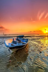 Long exposure picture of fishing boat with golden sunset as a background © hamdie