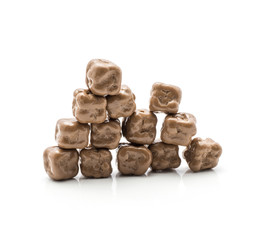 Milk chocolate coconut cubes put together in pyramid isolated on white background.